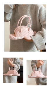 Detail showing the pink dolphin-shaped creative handbag with striped pattern and gold zipper