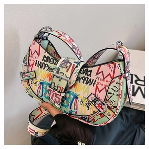 Detail of the colorful graffiti saddle bag featuring wide strap and buckle closure