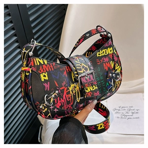 Close-up of graffiti print saddle bag with wide shoulder strap and metal hardware