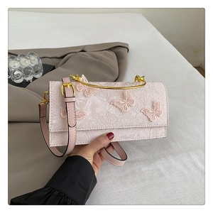 Détail du sac à main rose avec papillons 3D et poignée métallique dorée élégante