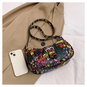 Detail view of black graffiti shoulder bag with colorful street art and silver buckle