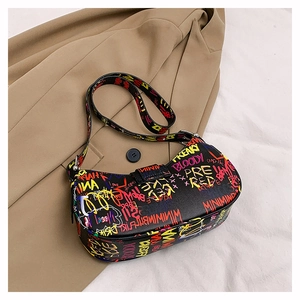 Detail of colorful street graffiti letters on black leather shoulder bag with silver buckle