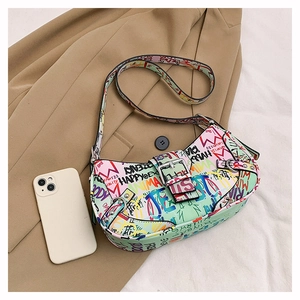 Detail shot of green graffiti print shoulder bag on a blazer with metal buckle and strap