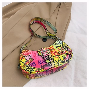 Detail of colorful graffiti saddle bag featuring metal buckle and rivet strap decor