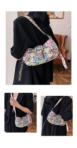 Close-up of street style graffiti print and silver buckle detail on the shoulder bag