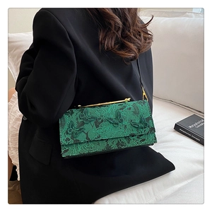 Détail du sac bandoulière vert avec texture papillon 3D et poignée dorée