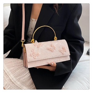 Gros plan sur les appliques papillon 3D et broderie en dentelle du sac rose