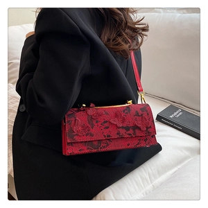 Détail du sac à main rouge en dentelle avec broderie papillon 3D et fermoir doré