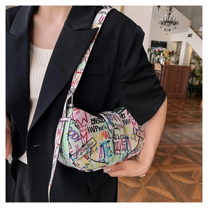 Detail of colorful graffiti saddle bag on model shoulder with adjustable strap