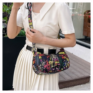 Detail of trendy graffiti print underarm bag with wide strap and metallic buckle