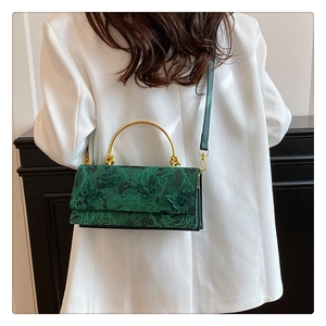 Détail du sac en dentelle verte avec broderie papillon 3D et poignée en métal doré