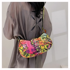 Close-up of colorful graffiti print and metal buckle detail on the trendy shoulder bag