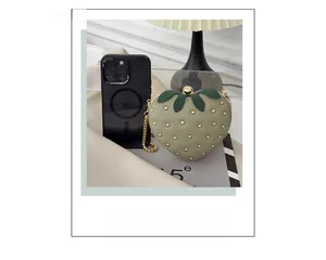 Vue détaillée du sac fraise vert à côté d'un téléphone pour montrer sa taille réelle