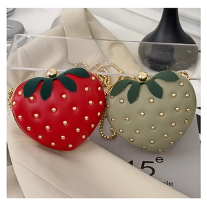 Détail de sacs fraises rouges et verts avec rivets dorés et bandoulières en métal