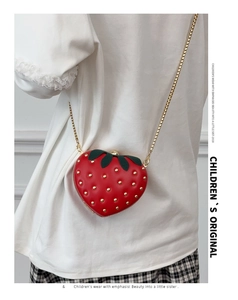 Détail du sac fraise rouge en forme de cœur avec clous dorés et bandoulière chaîne