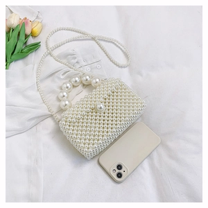 Détail d'un mini sac à main en perles tissées avec poignée et accents de tulipes