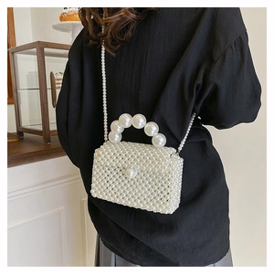 Détail du mini sac bandoulière en perles blanches avec poignée élégante et fine lanière