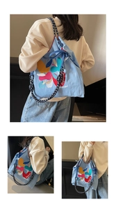 Detail of colorful leaf embroidery and Bafeisk text on blue canvas drawstring bag