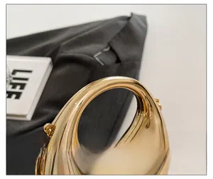 Close-up of polished gold acrylic dumplings bag with hollow handle and chain hooks