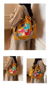 Detail of yellow nylon tote with apple embroidery and checkered straps on model