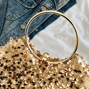 Detail of champagne gold sequin handbag with round metal handle and kiss-lock closure