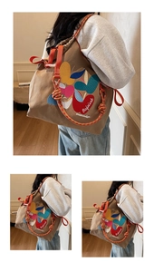 Detail of khaki canvas bag with colorful apple embroidery and orange rope shoulder straps