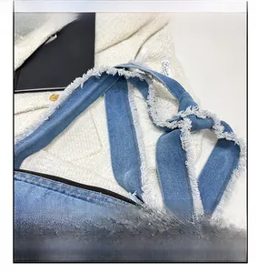 Détail macro d'une bandoulière en denim avec bords effilochés et un design de nœud décoratif