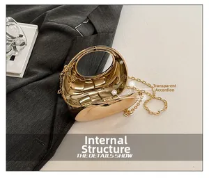 Macro view of metallic gold clutch bag with acrylic handle and transparent side gusset