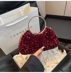Detail of wine red sequined evening clutch bag with gold round handle and chain strap