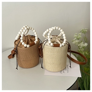 Detailed shot of woven bucket bags with wooden bead handles and drawstring inner lining