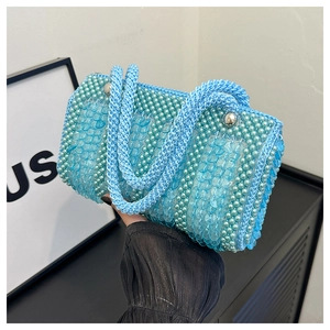 Macro view of mint green woven tote bag with pearl sequins and silver bead closure