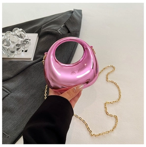 Detail view of pink metallic mirror finish acrylic clutch with gold chain shoulder strap