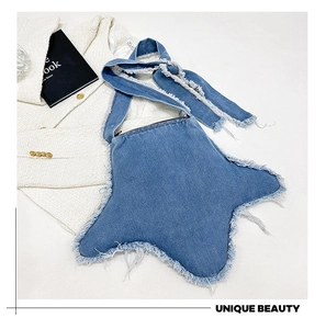 Détail du sac à bandoulière en denim en forme d'étoile avec des bords effilochés