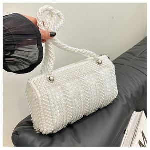 Detail view of the barrel bag showing intricate white pearl bead weaving and metal hardware