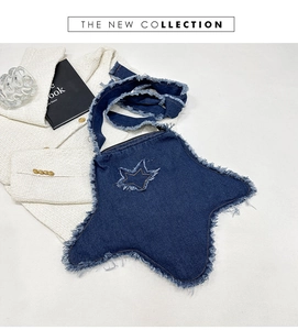 Détail du sac à bandoulière en denim bleu foncé en forme d'étoile avec finitions effilochées