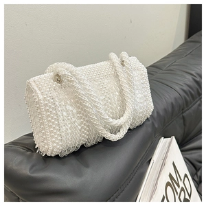 Detail of white handmade pearl woven handbag with clear sequins and woven handles