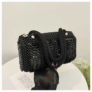 Detail of black Boston bag with layered sequins, beads, and silver flower charms