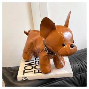 Detail of creative brown faux leather French Bulldog bag with studded collar on a book