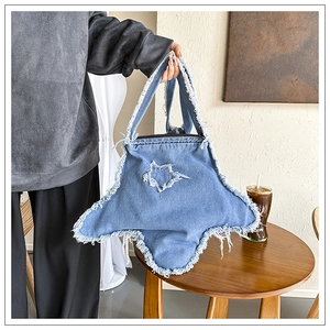 Vue détaillée du bord effiloché et du patchwork en jean en forme d'étoile sur le sac