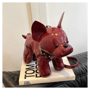 Detail of burgundy bulldog cross body bag with glossy finish and rivet collar on books