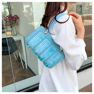 Detail of blue and white handmade beaded pillow bag with pearl handle for summer