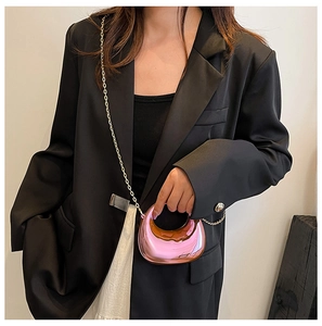 Macro detail of glossy metallic pink acrylic bag with golden crossbody chain