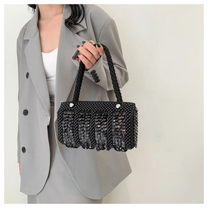 Detailed view of hand-woven black beaded handbag with layered sequins and woven handle