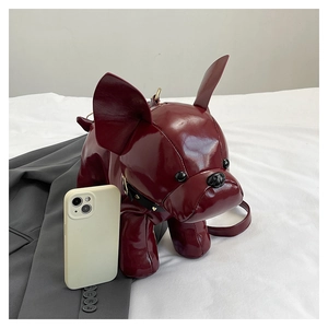 Detail of burgundy bulldog shaped crossbody bag with glossy finish and rivet collar