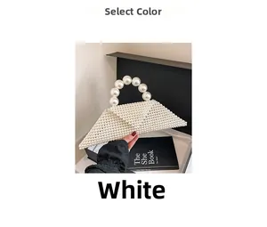 Detail shot of a white woven pearl handbag with a semi-circular handle on a black prop box
