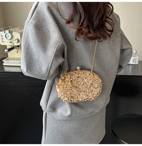 Detail of elegant gold sequined evening bag with diamond clasp and delicate chain strap