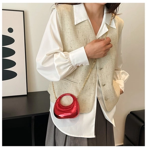 Mini red metallic acrylic bag with circular handle and gold chain strap on model