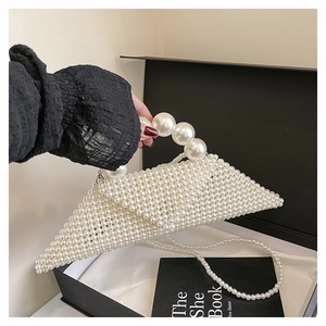 Detailed view of triangular white pearl handbag with large beaded handle and crossbody chain