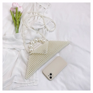 Detail of white handmade pearl woven bag with triangular structure and pearl shoulder strap
