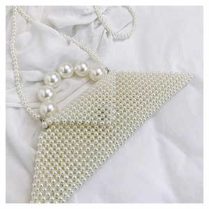 Detail of triangular woven pearl handbag with large bead handle and chain strap